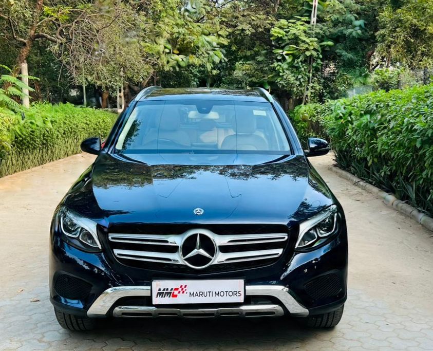 Blue Mercedes-Benz in lush greenery